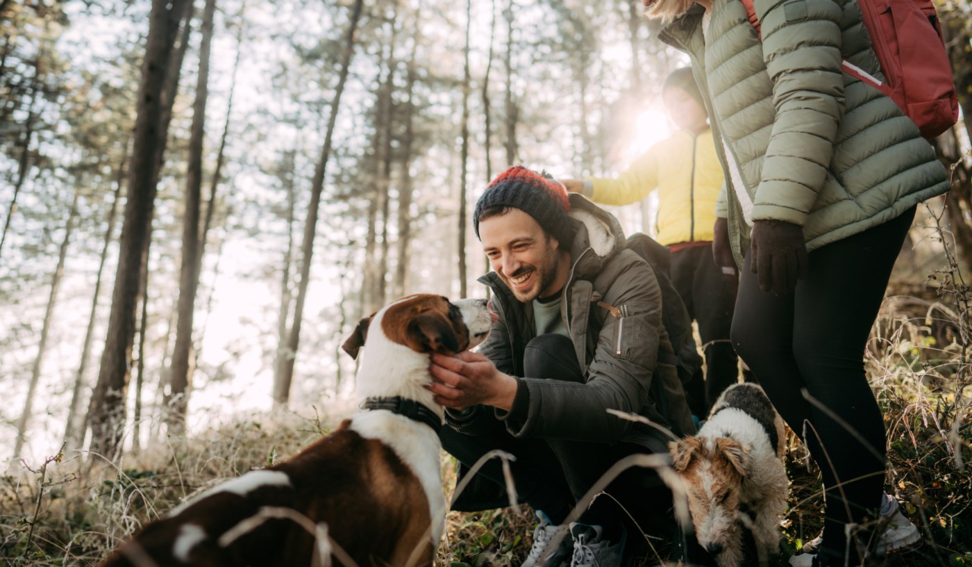 Familie på tur med hunden i skogen.
